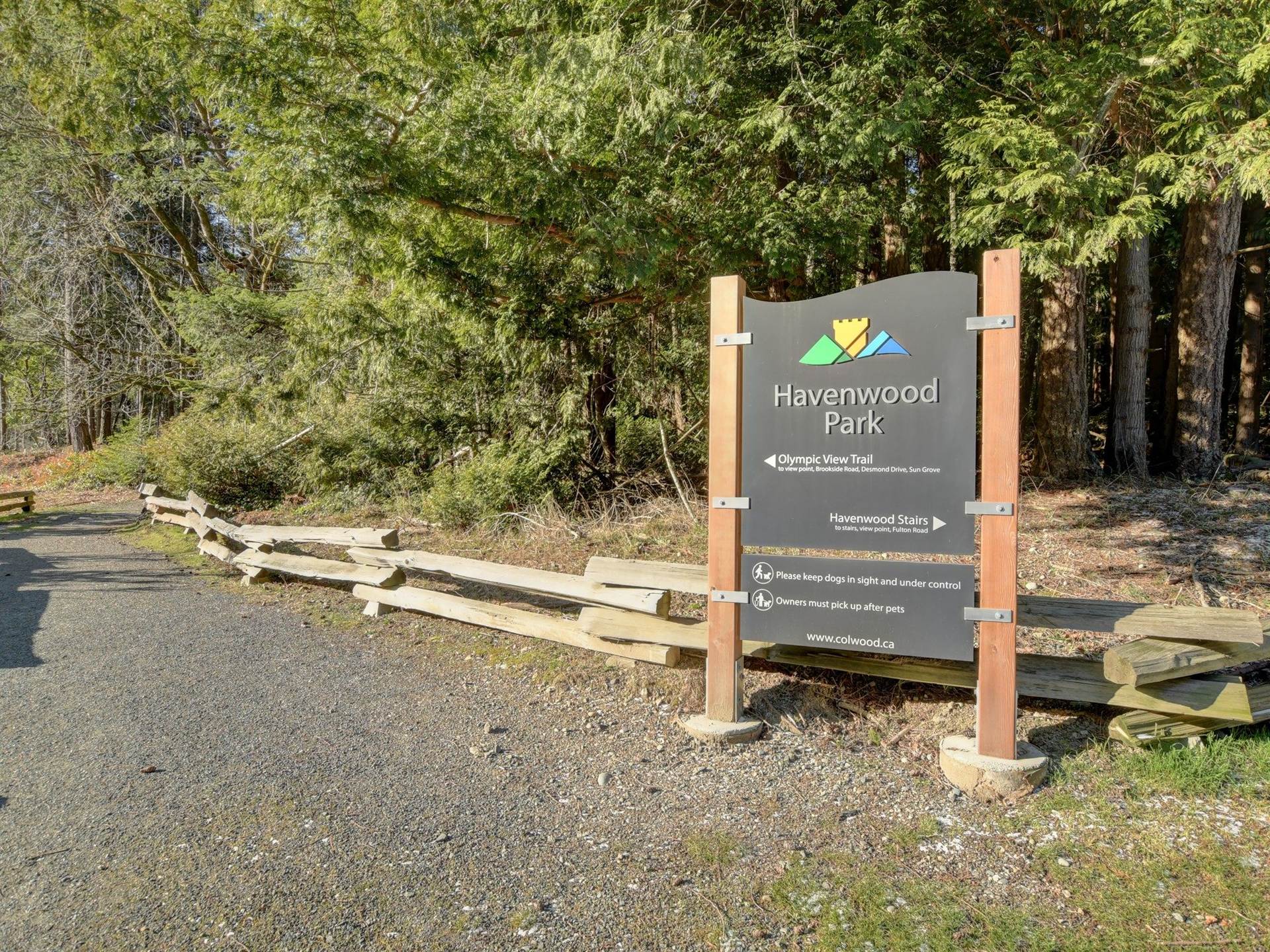 Havenwood Park trailhead sign in Colwood marking the Olympic View Trail, with a forest of tall trees behind