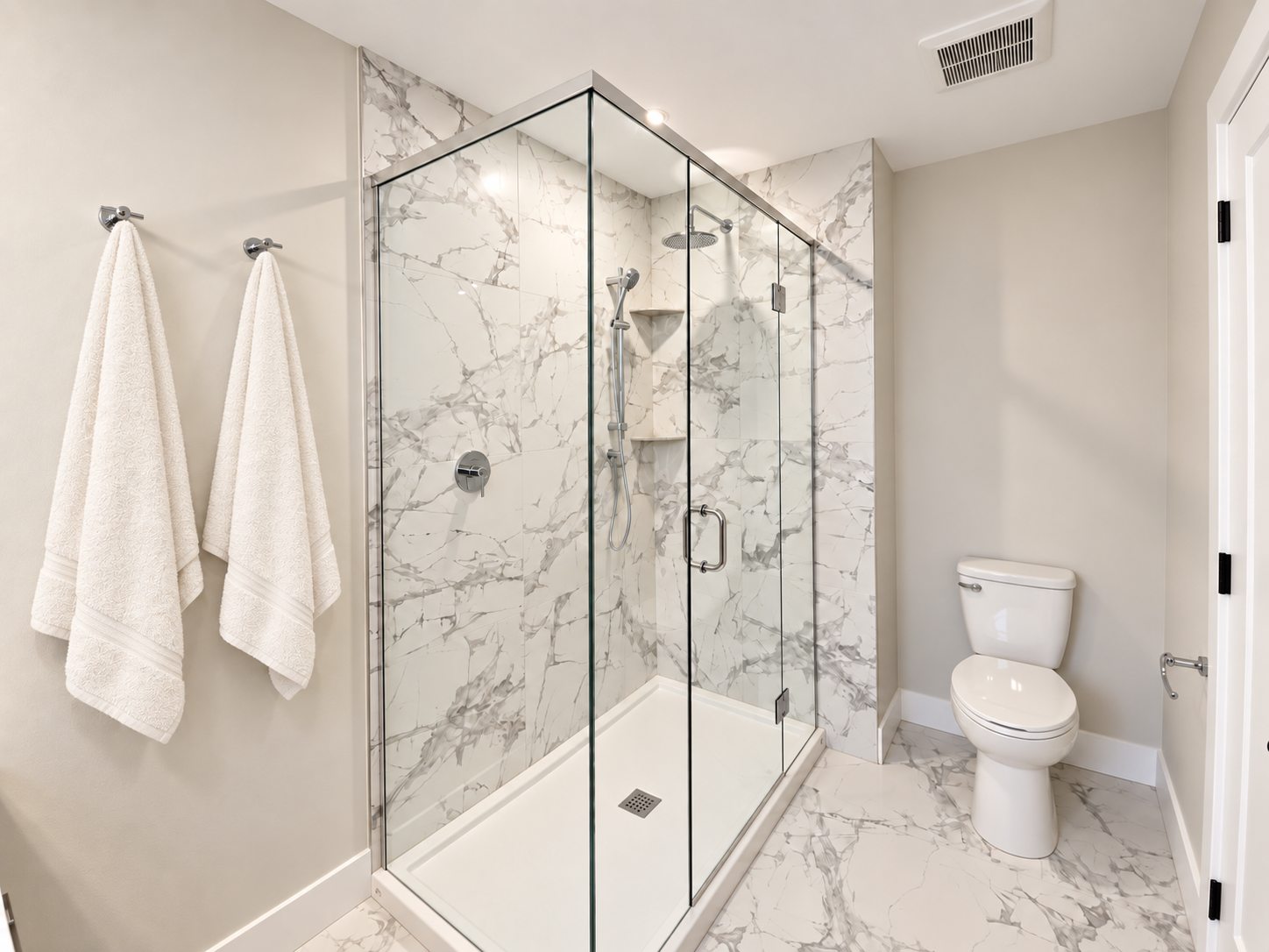 Coastwoods Phase 1 ensuite with a frameless glass shower and marble effect tile